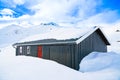 Cabin in the mountains covered in deep snow on a clear cold winters day