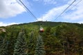 The cabin moves along the cable car up the mountain above the fo