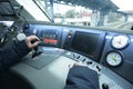 At the cabin of the passenger train. Train driver sitting of locomotive in front of the dashboard and putting hand on a start Royalty Free Stock Photo
