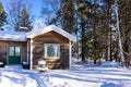 The cabin or small cottage is made of natural wood surrounded by high trees. Traditional typical old wooden house Royalty Free Stock Photo