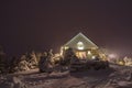 Cabin in the snow between snowcovered pine trees Royalty Free Stock Photo