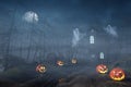 Cabin in a Halloween forest with pumpkin lanterns at night Royalty Free Stock Photo