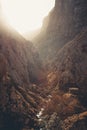 Cabin in the valley of a massive rocky mountain with the sun over it with a lot of copy space Royalty Free Stock Photo