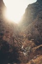 Cabin in the valley of a massive rocky mountain with the sun over it with a lot of copy space Royalty Free Stock Photo