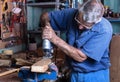 Cabinet maker working with wood saw in the workbench in garage a