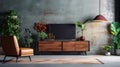 Cabinet TV in a gorgeous living room with an armchair, lamp, table, flower, and plant on a concrete wall background Royalty Free Stock Photo