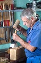 Cabinetmaker carving wood with a chisel and hammer Royalty Free Stock Photo