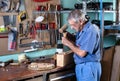 Cabinetmaker carving wood with a chisel and hammer in workbench