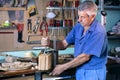 Cabinetmaker carving wood with clamp in workbench