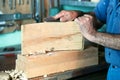 Cabinetmaker working with sandpaper in the bench in garage at ho