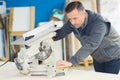 Cabinetry worker using drop saw to cut plank Royalty Free Stock Photo