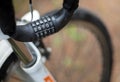Cable for attaching a bicycle with a combination lock hanging on the handlebars with a blurred wheel background