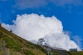 Cable car on a background of mountains and blue sky with clouds in Krasnaya Polyana.