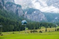 Cable car cabins against amazing Dolomites Alp covered with clouds