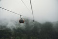 Cable car climbing up to foggy hill over thick forest in Banahill, Danang