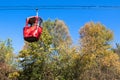 Cable car with colored cabins in autumn.