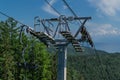 Cable Car Construction With Seats Among Coniferous Trees In Green Forest On Hill In Mountains, Sunny Blue Sky, Baikal Lake