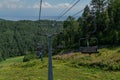 Cable Car Empty Seats Among Trees, Grass Field In Green Forest On Hill, Sunny Summer Blue Sky With White Clounds, Baikal Lake