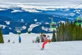 Cable car gondola ski lift and skiers on the slope in Voineasa, Romania Royalty Free Stock Photo