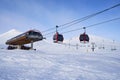 Cable car gondola at ski resort with snowy mountains on background. Modern ski lift with funitels and supporting towers Royalty Free Stock Photo