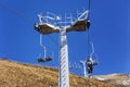 Cable car with lifting mechanisms in the mountains on a clear sunny day against a blue sky. Active recreation and winter sports