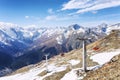 Cable car with lifting mechanisms in the snow-capped mountains on a clear sunny day against the backdrop of a blue cloudy sky.