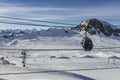 Cable car in the mountains and white snowy ski slopes. Snowy winter mountain background. Royalty Free Stock Photo