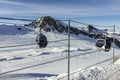 Cable car in the mountains and white snowy ski slopes. Snowy winter mountain background. Royalty Free Stock Photo