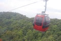 A cable car is moving uphill on the ropeway for tourists to visit lush green mountain valley on a popular tourist destination. Royalty Free Stock Photo