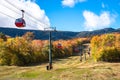 Cable car over a forested slope at the peak of fall foliage colors Royalty Free Stock Photo