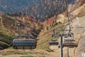 Cable car road with grey cabines at autumn forest landscape. Soshi, Rosa Khutor