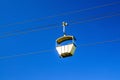 Cable car on rope of cableway, blue clear sky background in sunny summer day Royalty Free Stock Photo