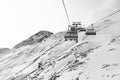 Cable car at a ski resort. Chairlift with skiers. Mountains covered with snow