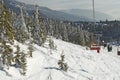 Cable cars and chair lifts in ski resort . Mountains with white snow, blue sky. Downhill fun at snowy slopes