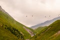 Cable cars between villages in northern Georgia in the Caucasus Mountains high over a valley with a glacier in the distance -