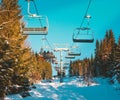 Cable chair lifts at a ski resort with skiers riding to the top of the slopes