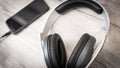 Modern headphones connected to music player on wooden table Royalty Free Stock Photo