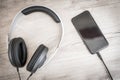 Modern headphones connected to music player on wooden table Royalty Free Stock Photo