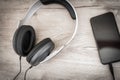 Modern headphones connected to music player on wooden table Royalty Free Stock Photo