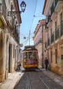 Cable going through a narrow alley surrounded by buildings under a sunny sky in Lisbon, Portugal