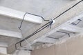 Cable laying the ceiling. Electrical wires on the wall. Wiring replacement. Connecting the light in the flat or office. Royalty Free Stock Photo