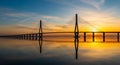 Cable-stayed bridge at sunset with vibrant sky and water reflections architecture engineering Royalty Free Stock Photo
