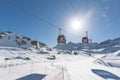 Cableway lift cable cars, gondola cabins on winter snowy mountains background beautiful scenery.