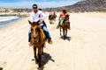 Tourists horseback riding on the beach in Cabo San Lucas, Baja California