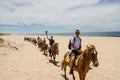 Tourists horseback riding on the beach in Cabo San Lucas, Baja California