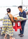 A Cabodian Riverside food seller gets help,moving her stall to a different area