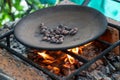 Cacao beans roasting over a fire on a primitive grill, view from downward angle Royalty Free Stock Photo