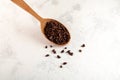 Cacao nibs in wooden spoon on grey surface, close-up. Sugar-free product. Natural antidepressant. Crushed cocoa beans of weak Royalty Free Stock Photo