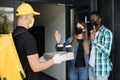 Cacasian man in face mask works on the delivery of pizza. Royalty Free Stock Photo