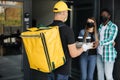 Cacasian man in face mask works on the delivery of pizza. Royalty Free Stock Photo